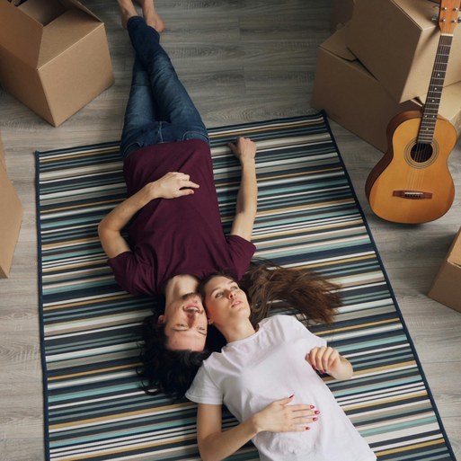 Couple taking a break during their home move surrounded by boxes