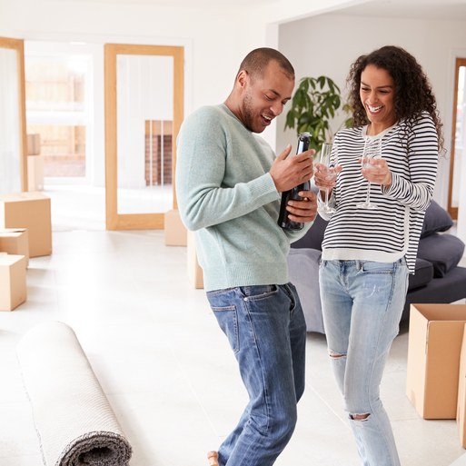 Couple celebrating in their new home with moving boxes